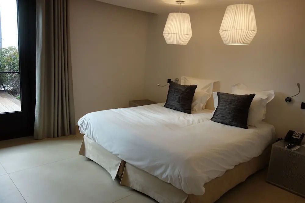 Elegantes Schlafzimmer mit Doppelbett und modernen Nachttischlampen.