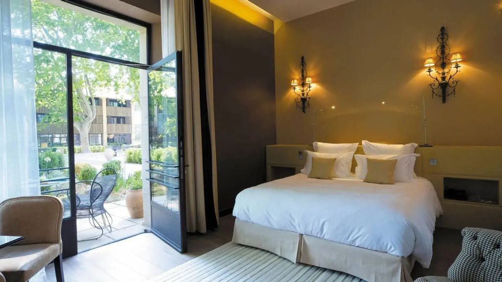 Elegantes Zimmer mit Doppelbett, offener Tür und Blick auf den Garten