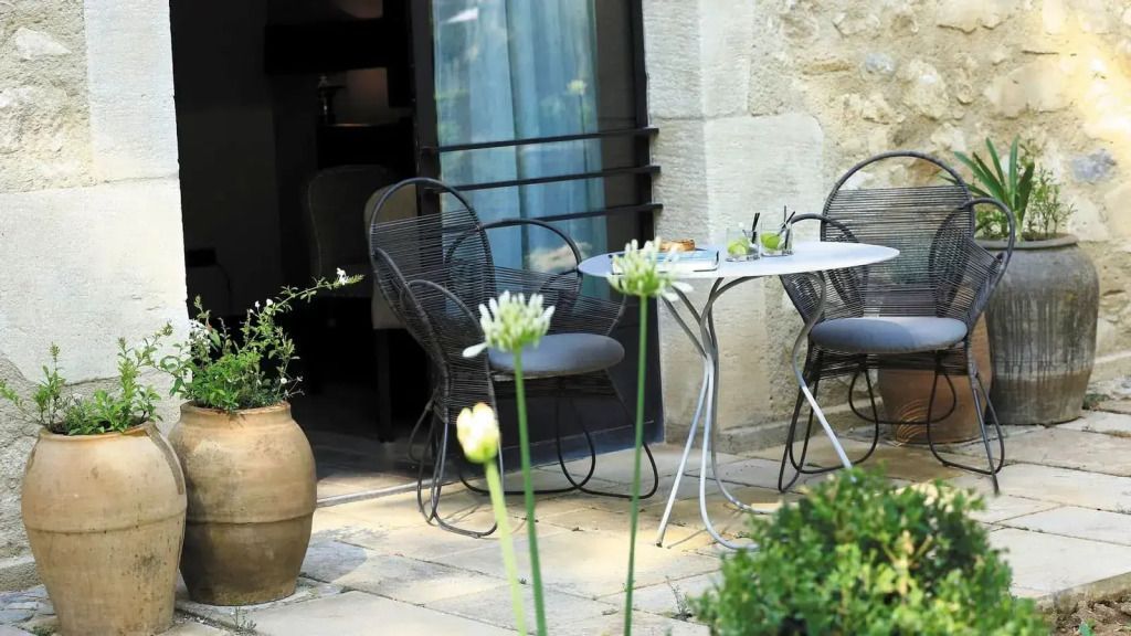 Terrasse mit Blick auf einen charmanten Garten, ausgestattet mit Tisch und Stühlen