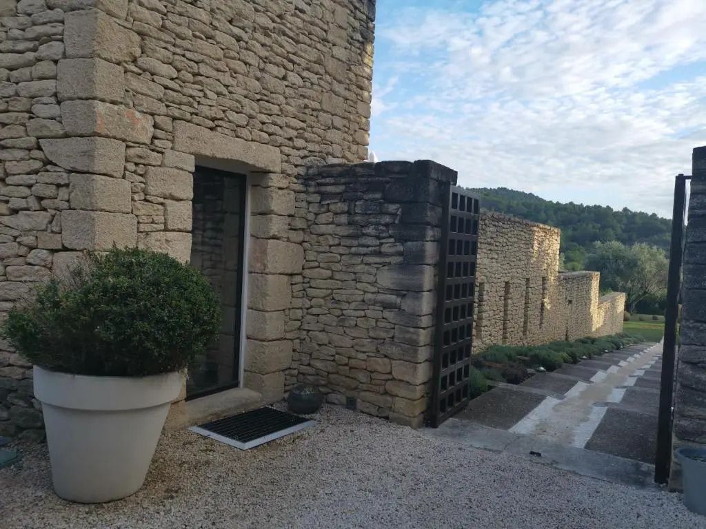 Steingemauerte Hotelvilla mit Kiesweg und Topfpflanze