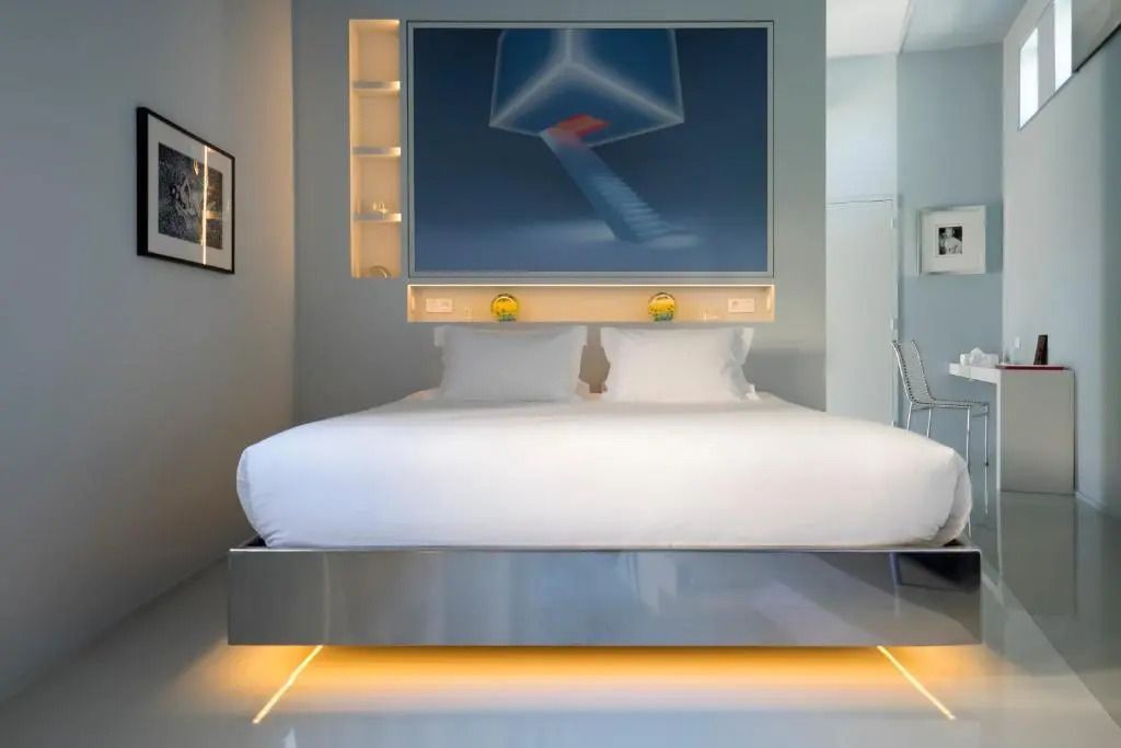 Modernes Doppelbett mit künstlerischem Wandbild und eleganter Beleuchtung
