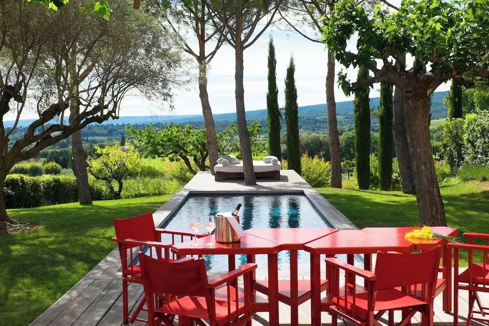 Terrasse mit Pool und eleganten roten Gartenmöbeln