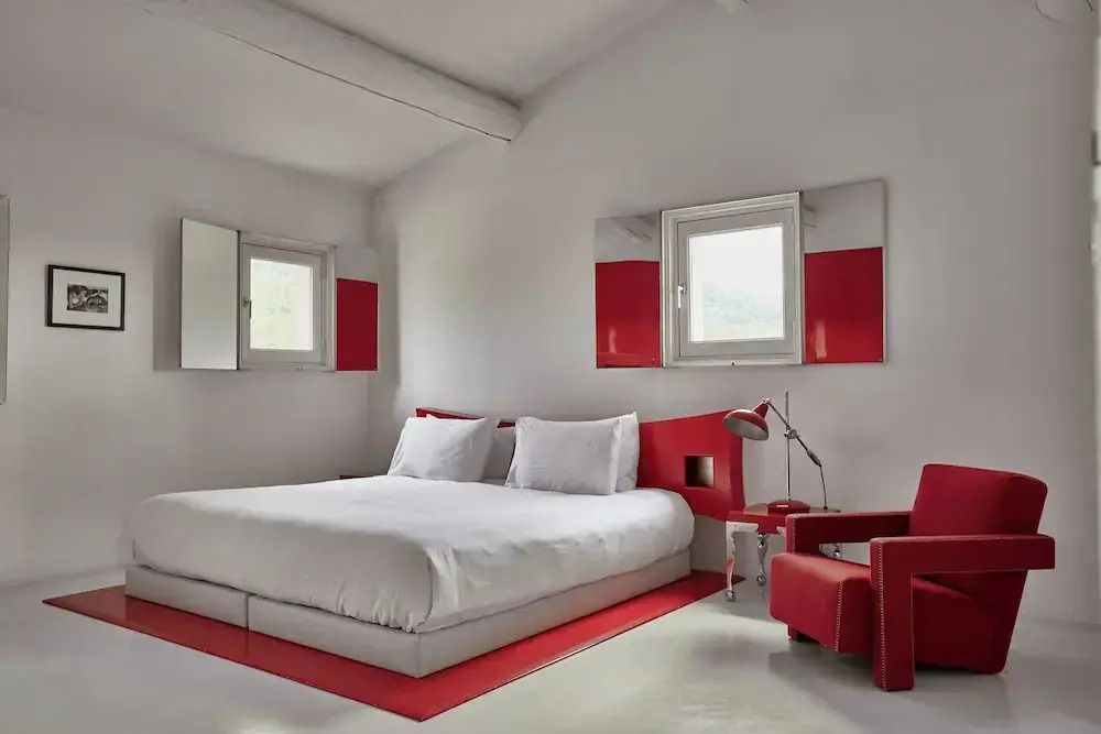 Helles Schlafzimmer mit rotem Dekor und modernen Möbeln