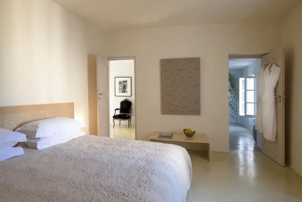 Helles Schlafzimmer mit Kunstwerk an der Wand und Designerstuhl