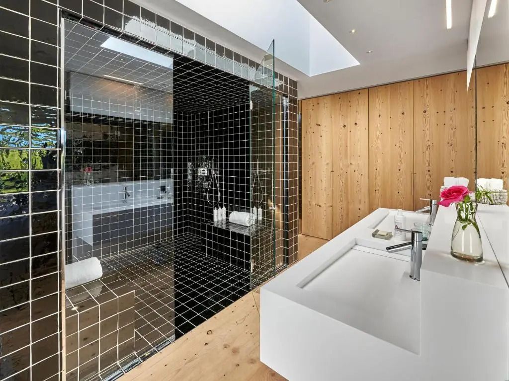 Modern gestaltetes Badezimmer mit Glaswand und Doppelwaschbecken in der Junior-Suite