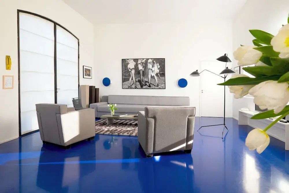 Moderner Wohnbereich mit blauem Boden und stilvoller Kunst