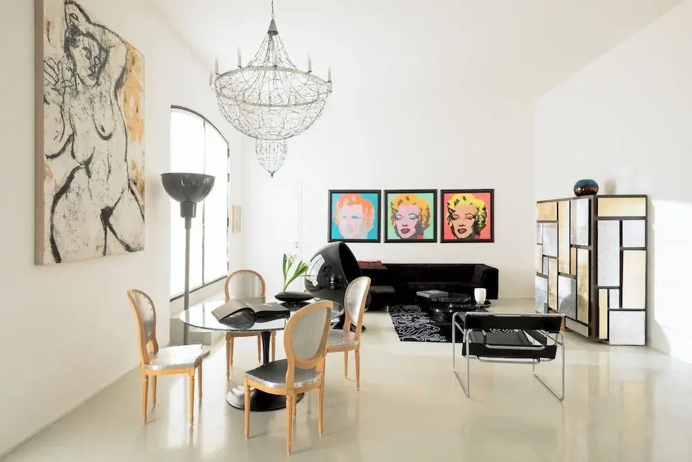 Luxuriöser Raum mit Kronleuchter und Pop-Art-Bildern
