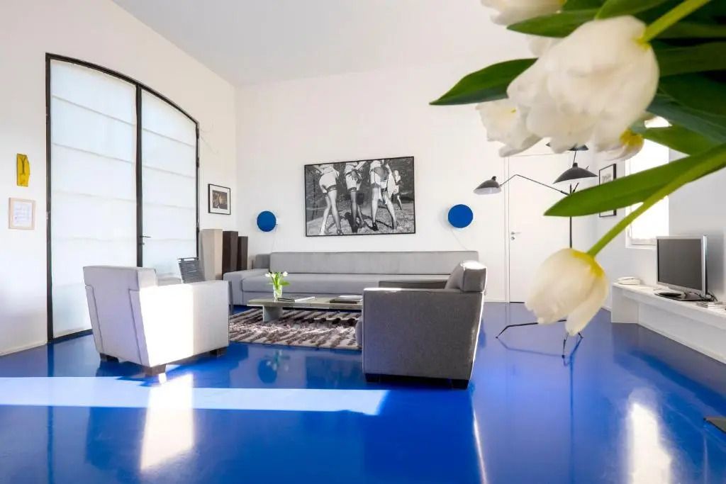 Geräumiges Wohnzimmer mit blauem Boden und stilvoller Einrichtung