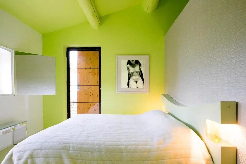 Gemütliches Schlafzimmer mit Kunstwerk und heller Farbgebung