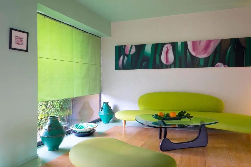 Stilvoller Lounge-Bereich mit grüner Dekoration und Kunst an der Wand