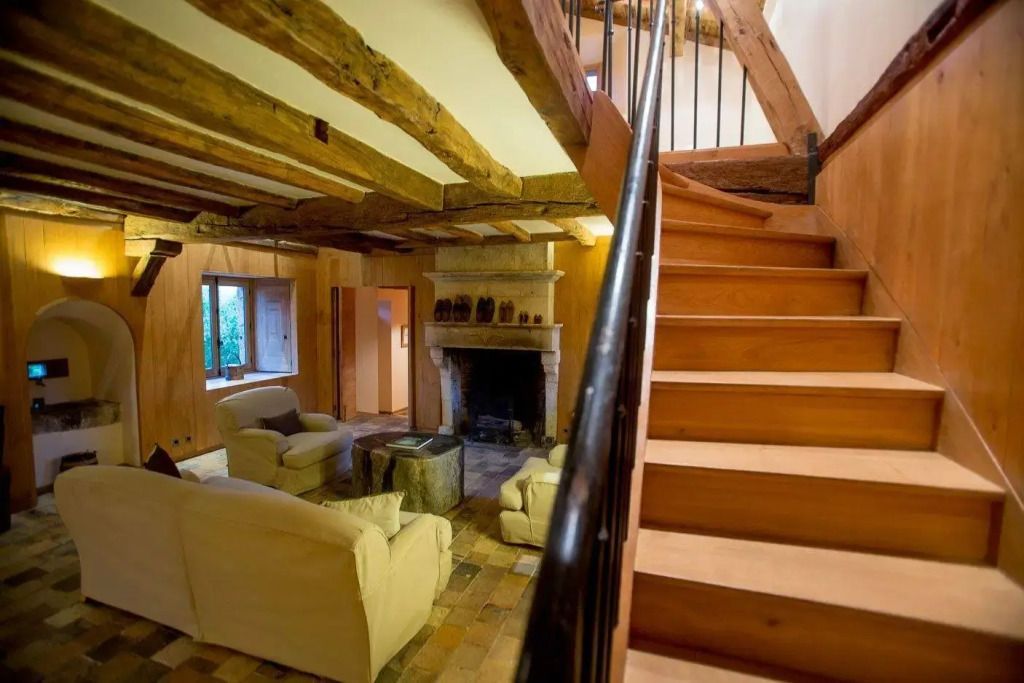 Gemütliches Wohnzimmer in der Centaure Hütte mit Kamin und Holzbalken.