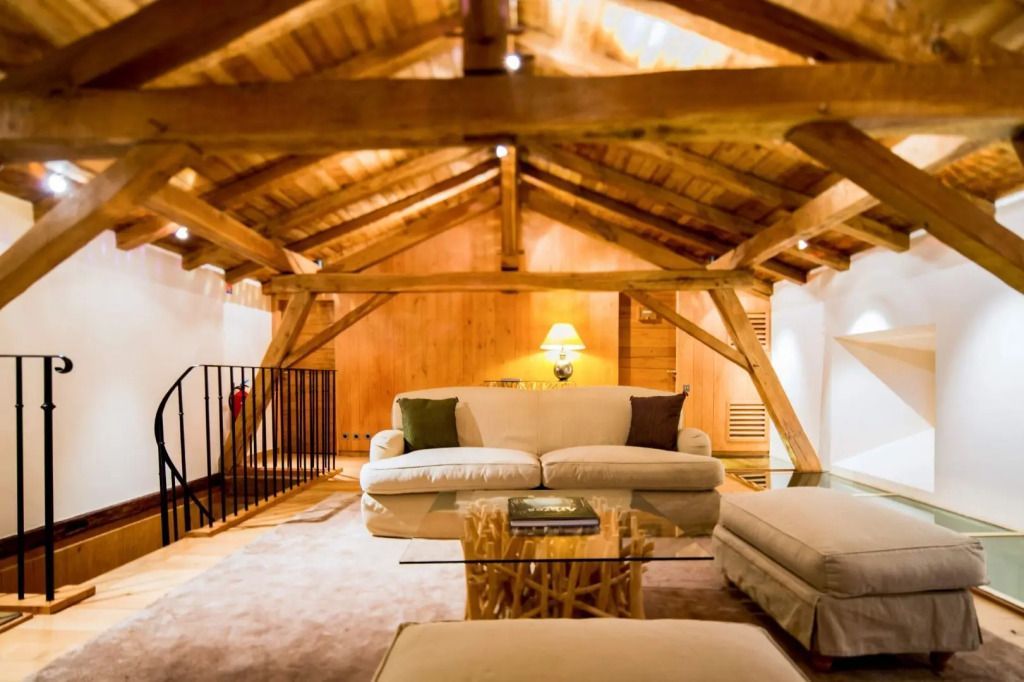 Eleganter Dachboden mit gemütlichen Sofas und Holzbalkendecke.