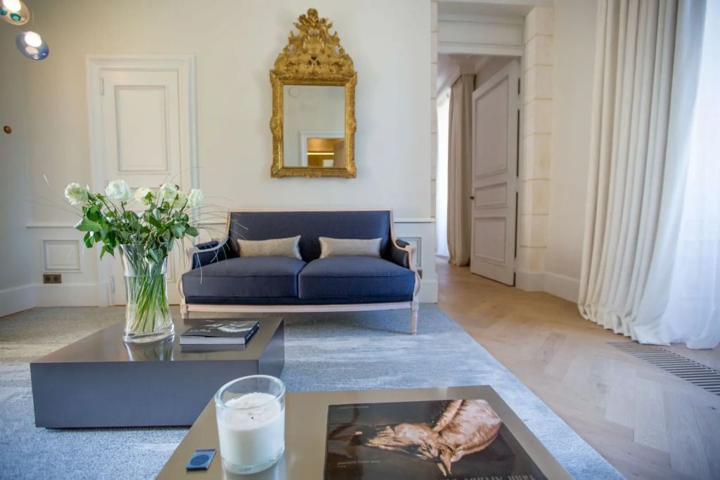Elegante Sitzecke mit blauer Couch und goldverziertem Spiegel