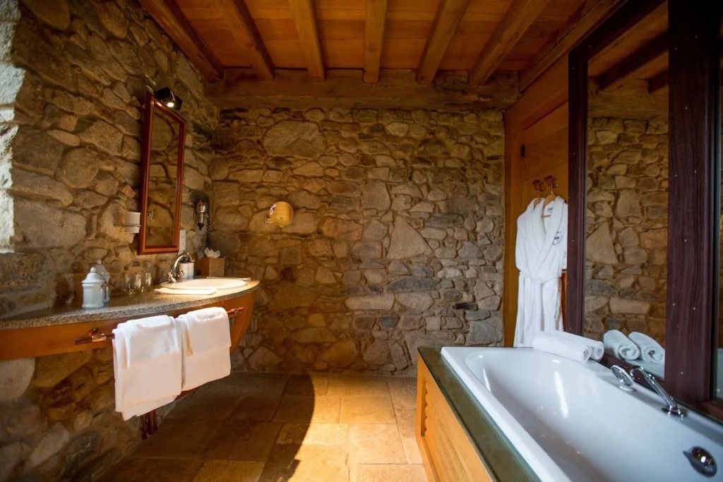 Luxuriöses Badezimmer mit freistehender Badewanne und Steinwand