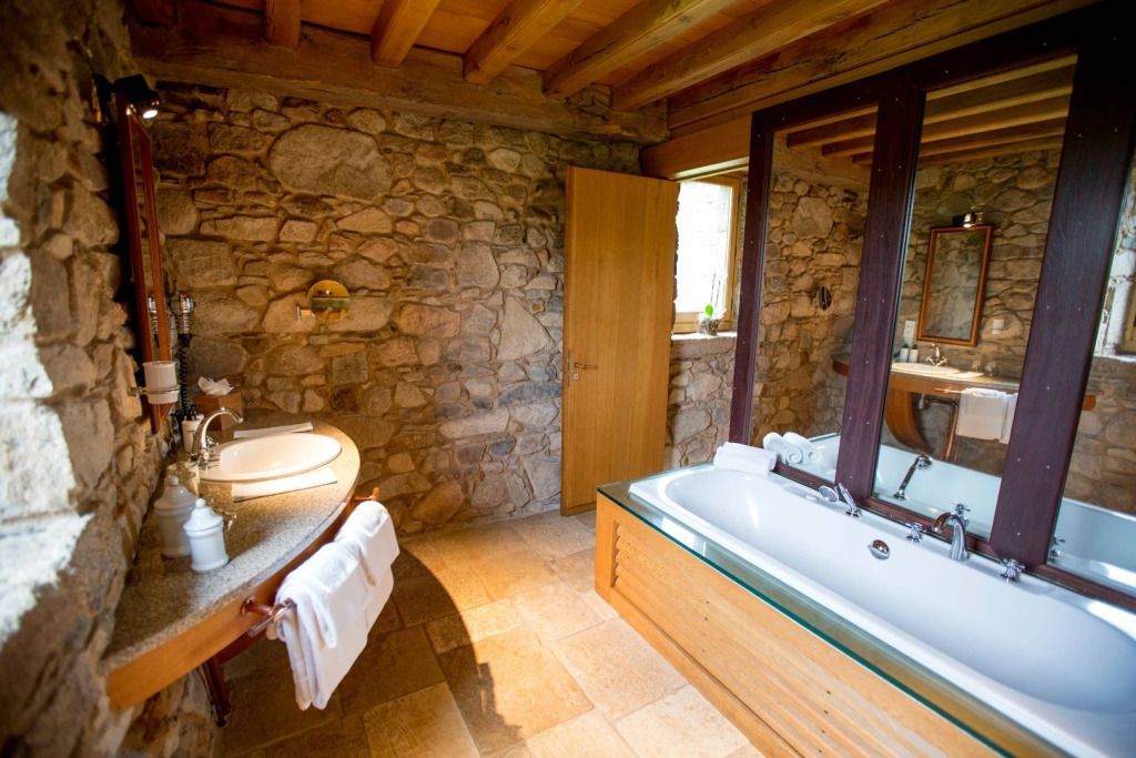 Badezimmer im Landhausstil mit Steinwänden und Holzdecke