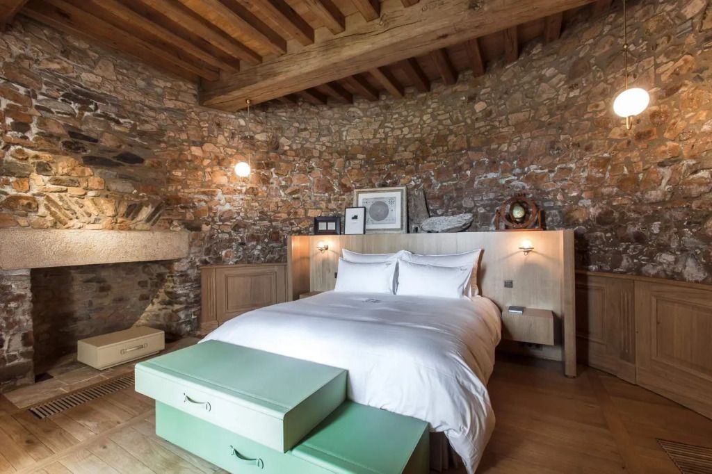 Rustikales Schlafzimmer mit Holzbalken und Steinwänden im Mercure Prestige Doppelzimmer.