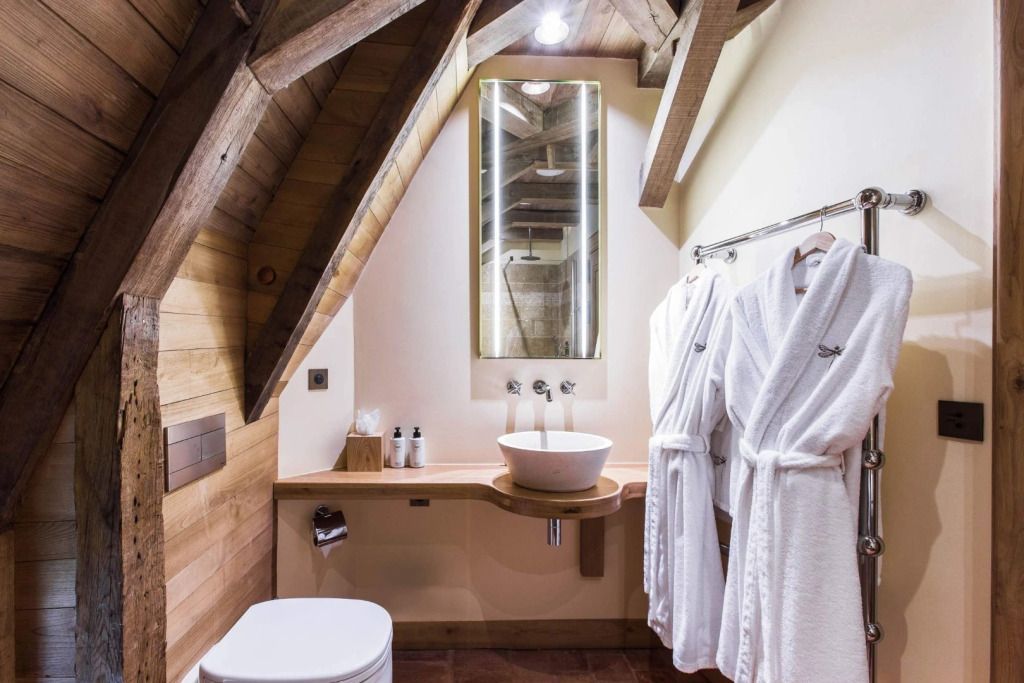 Modernes Badezimmer mit Holzverkleidung und luxuriösen Bademänteln im Hotelzimmer.