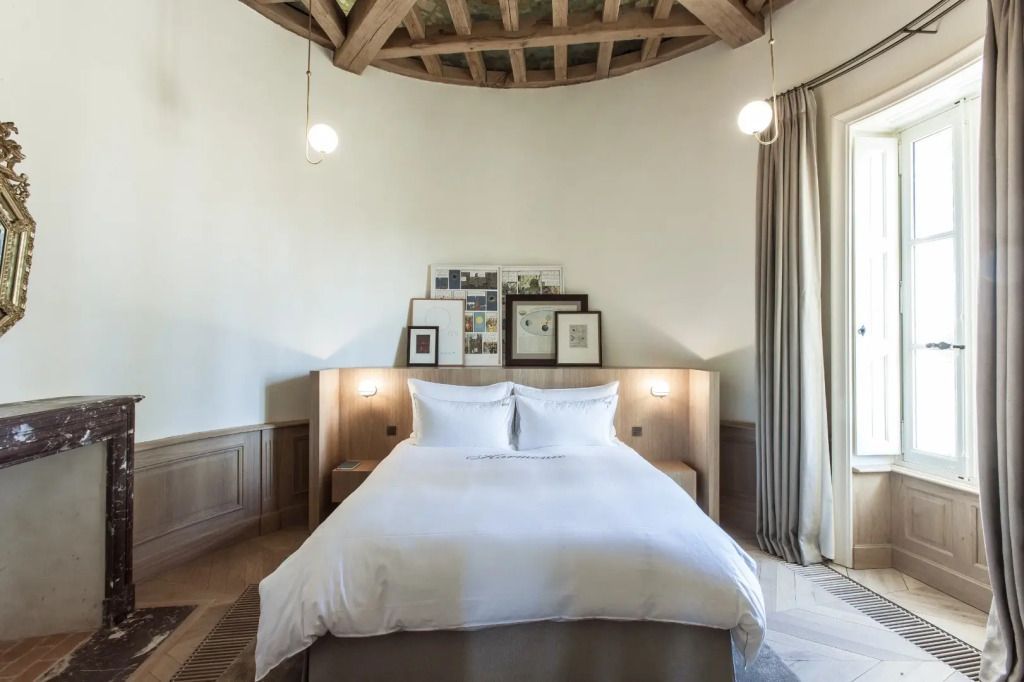 Helles Schlafzimmer mit rustikaler Holzdecke und Doppelbett in der Soleil Prestige Suite