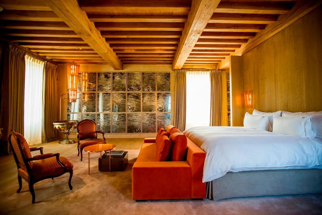 Luxuriöse Suite mit Holzbalken, Doppelbett und roten Sofa-Elementen