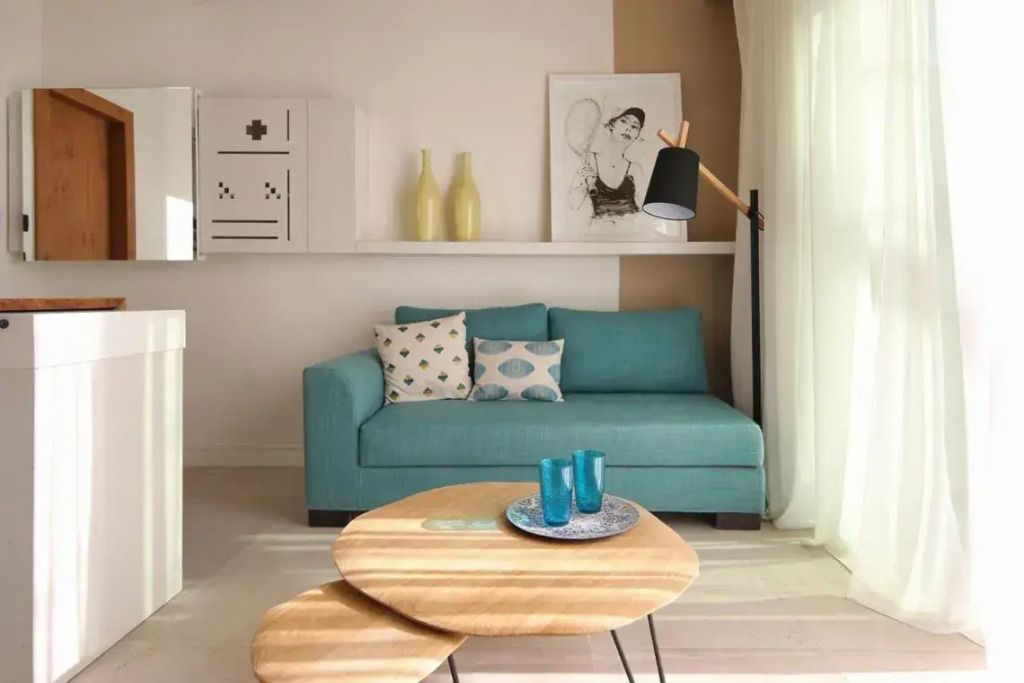 Gemütliches Wohnzimmer mit türkisfarbenem Sofa und eleganten Dekorationen.