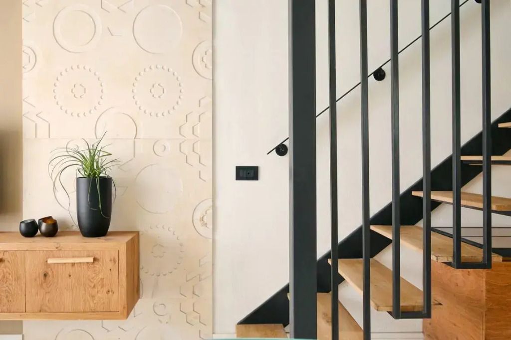 Moderne Treppe mit elegantem Pflanzenarrangement und dekorativer Wand.