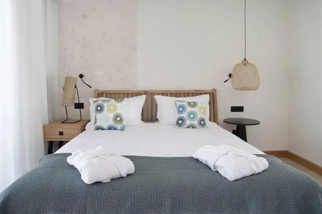 Helles Schlafzimmer mit Doppelbett und stilvoller Dekoration.