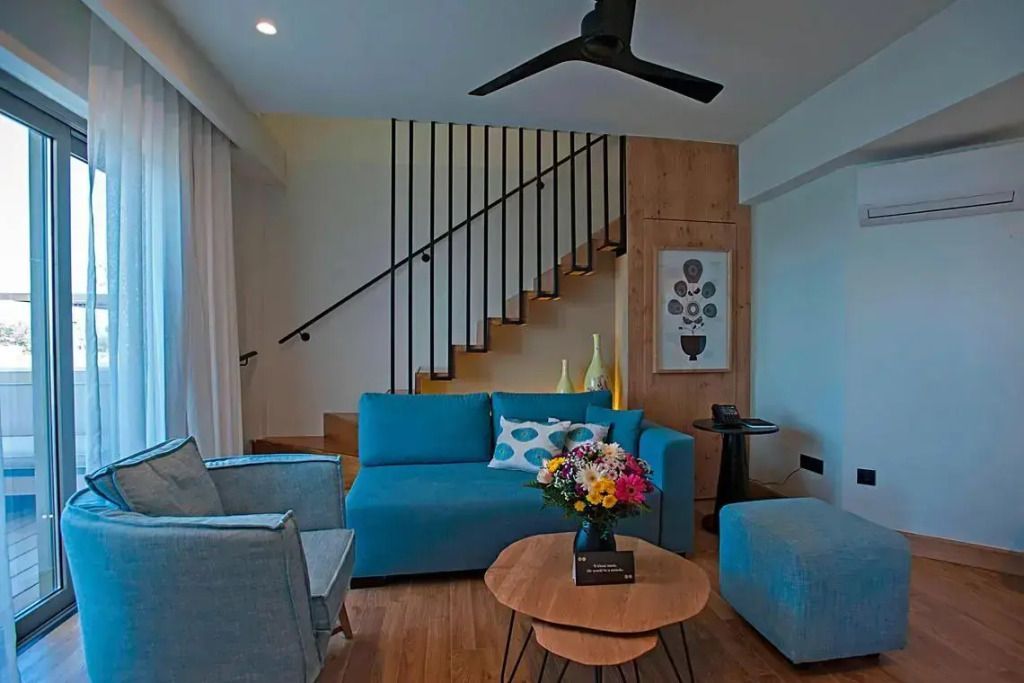 Wohnbereich in der Suite mit moderner Einrichtung und Treppe.