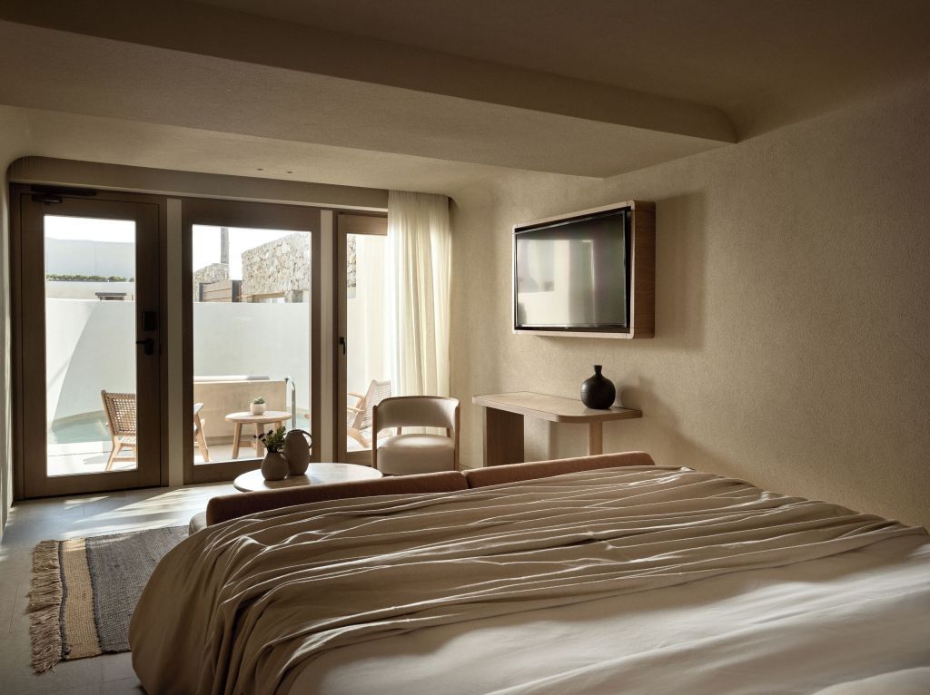 Helles Zimmer mit großem Bett und Zugang zur Terrasse bei Tageslicht