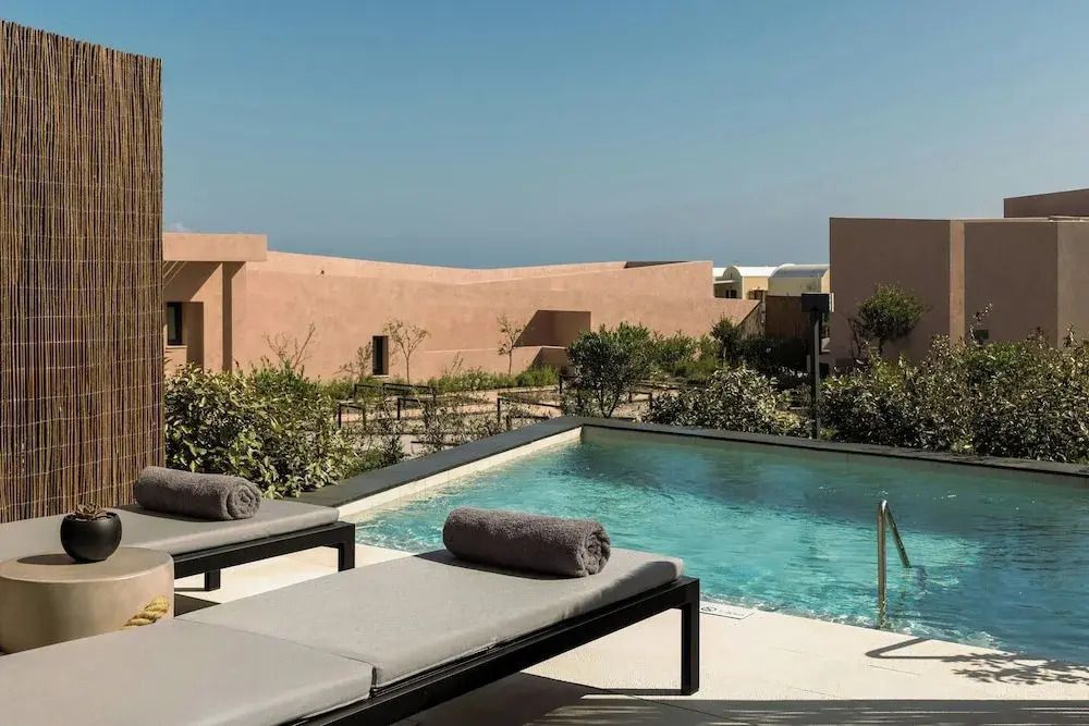 Luxuriöser Poolbereich mit Sonnenliegen im Hotel Santorini.