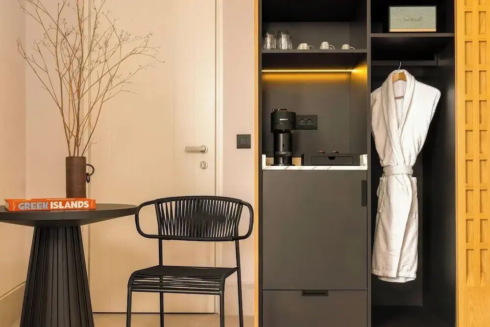 Detail des Zimmers mit Sessel, Kaffeemaschine und Bademantel im Schrank