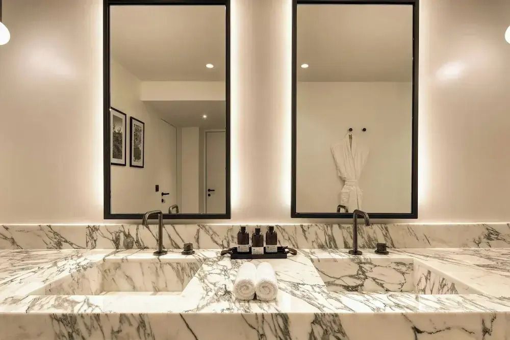 Elegantes Badezimmer mit Marmorwaschbecken und großen Spiegeln