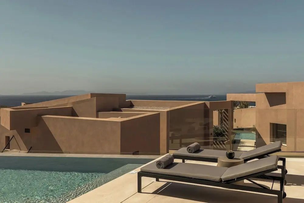 Privater Poolbereich der Villa mit Blick auf das Meer unter klarem Himmel.
