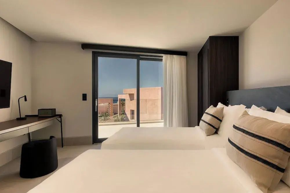 Helles Schlafzimmer mit zwei Einzelbetten und Blick auf die Terrasse.