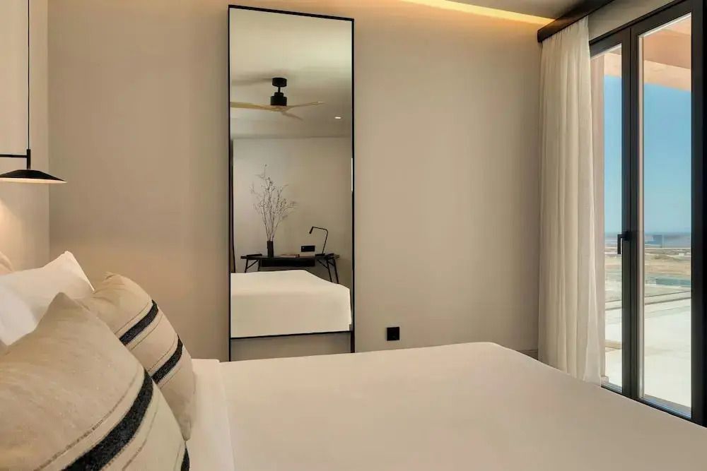 Schlafzimmer mit großem Spiegel und stilvollen Einrichtungsdetails.