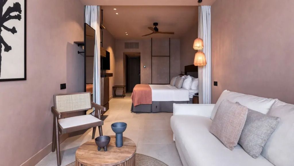 Elegante Junior-Suite mit Doppelbett, Sofa und moderner Einrichtung.