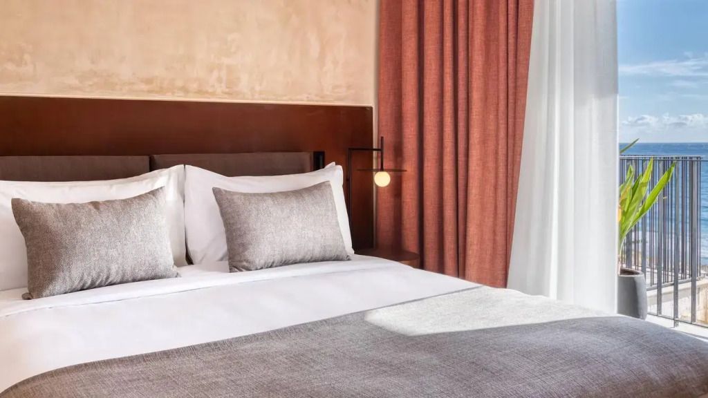 Modernes Schlafzimmer mit Doppelbett und eleganten Vorhängen in warmen Farben