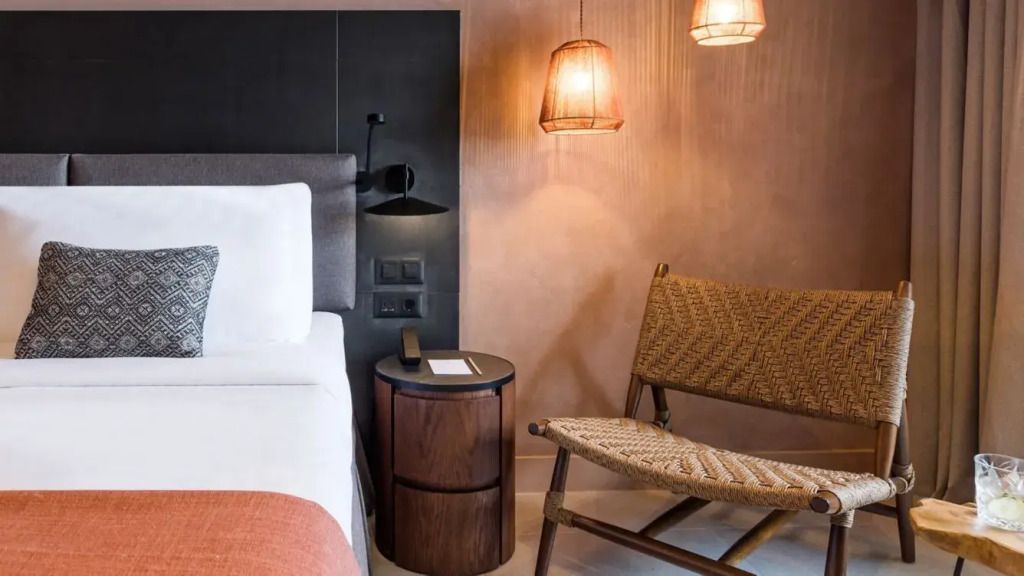 Gemütlicher Lesebereich mit Stuhl, Nachttisch und sanfter Beleuchtung im Hotelzimmer