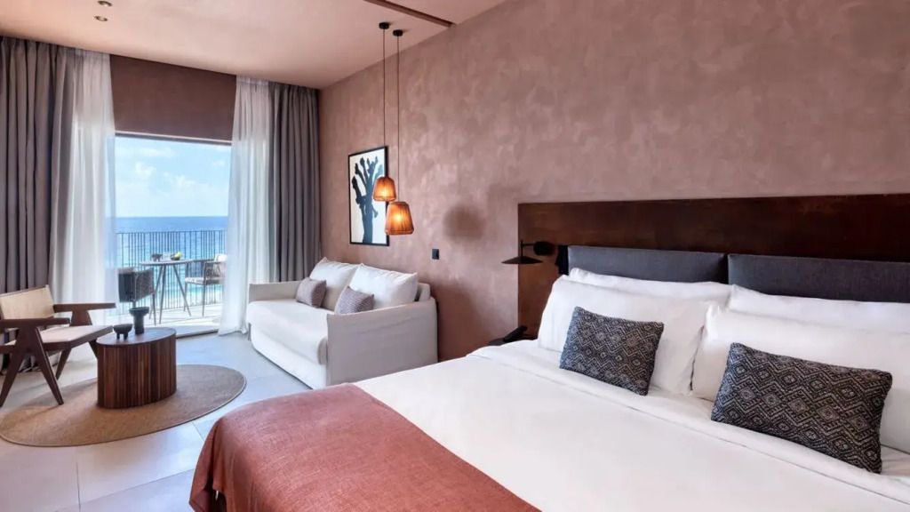 Elegantes Zimmer mit Doppelbett, Meerblick und stilvoller Dekoration.