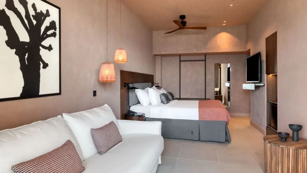 Geräumiges Gästezimmer mit Doppelbett, Sofa und moderner Beleuchtung.