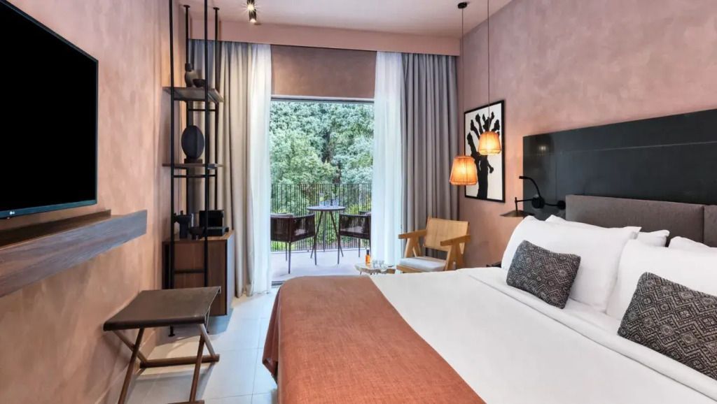 Elegantes Hotelzimmer mit Doppelbett, Balkon und Bergblick.