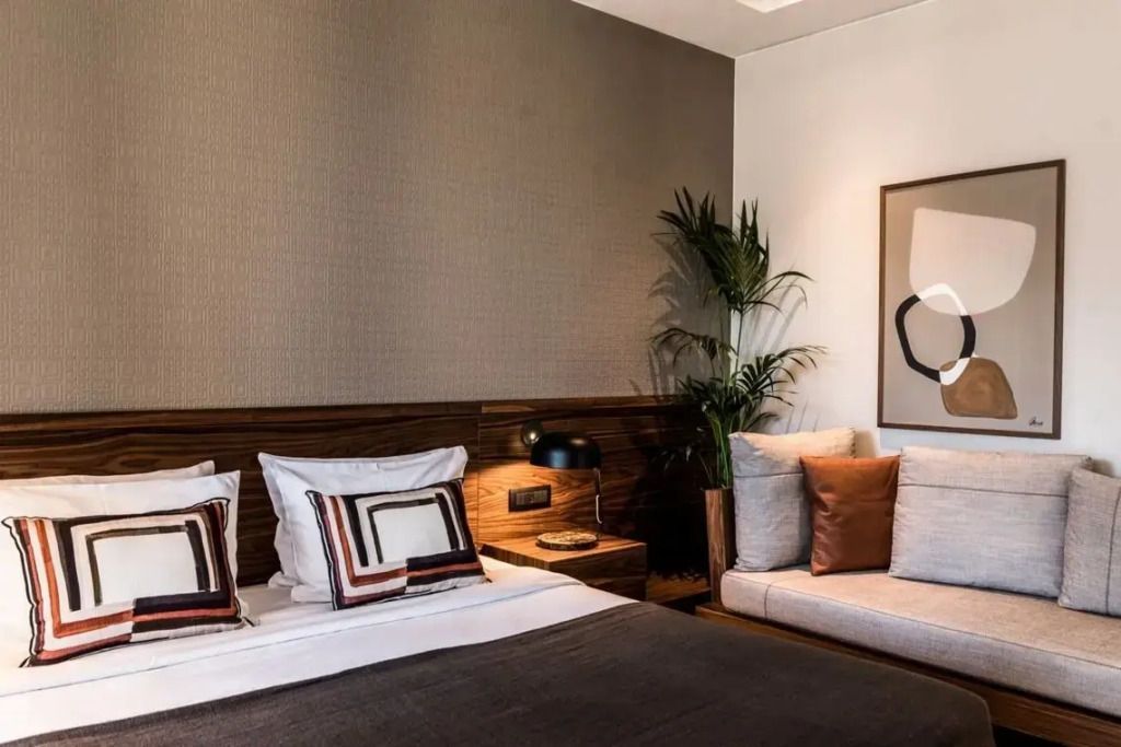 Doppelbett mit moderner Kunst an der Wand und Pflanzen im Raum