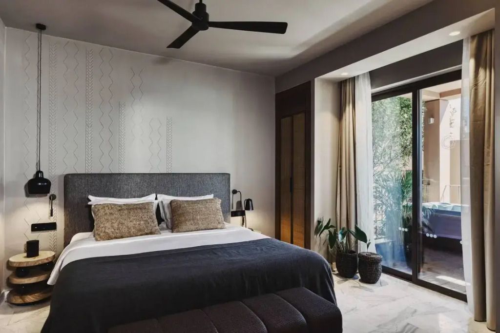 Modernes Schlafzimmer mit Doppelbett und Zugang zum Balkon im natürlichen Licht