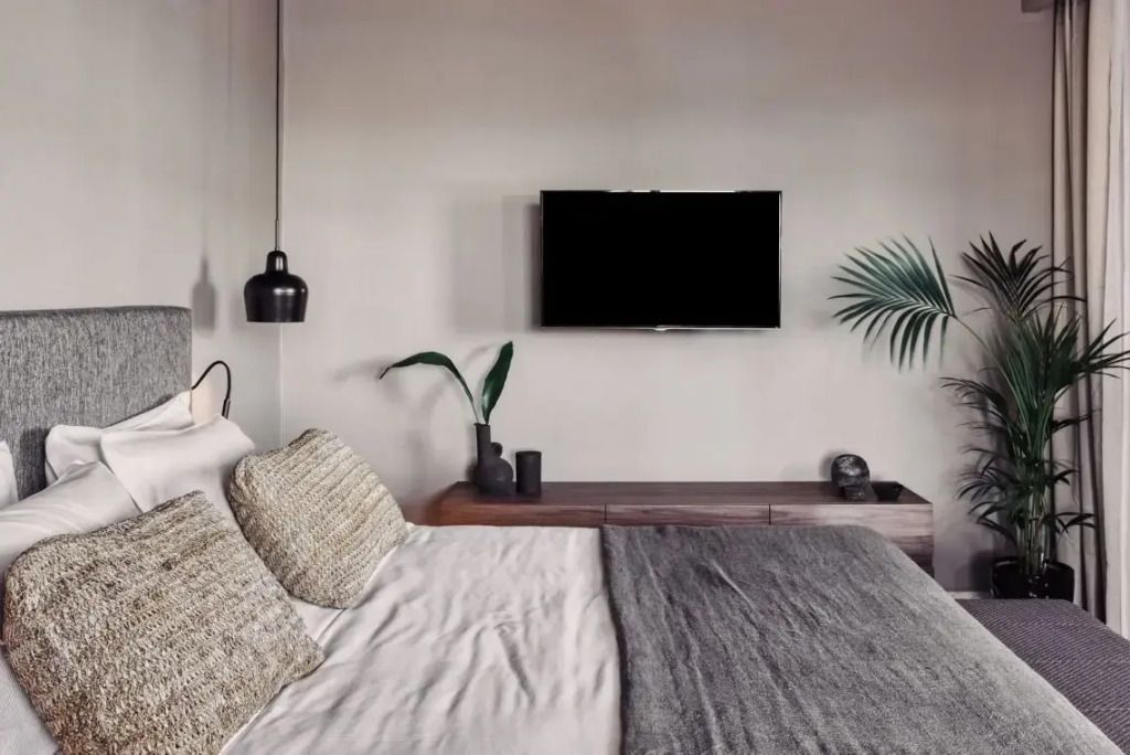 Schlafzimmer mit Flachbildfernseher und modernen Dekorationsakzenten