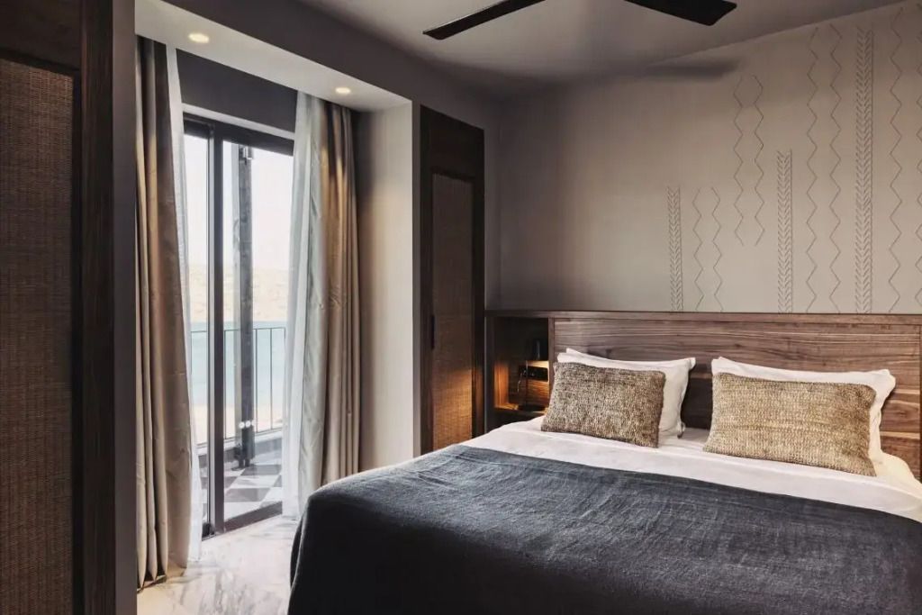 Modernes Schlafzimmer mit Doppelbett und Balkon mit Meerblick