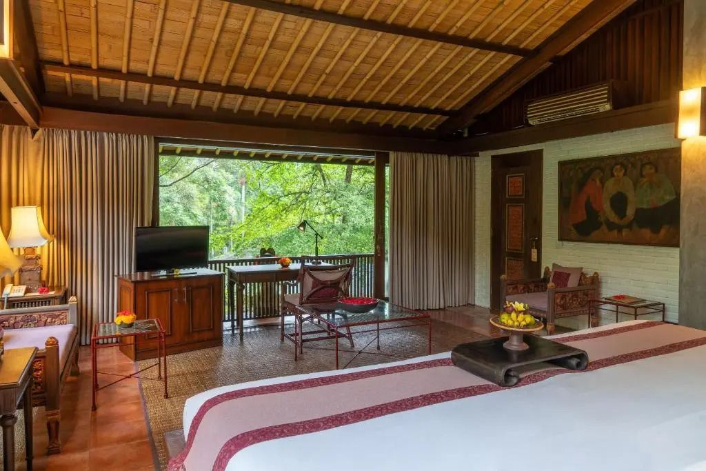 Gemütliches Hotelzimmer mit großem Bett und Ausblick auf die Natur.