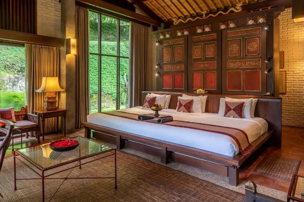 Luxuriöses Schlafzimmer mit aufwendigem Dekor und großen Fenstern.