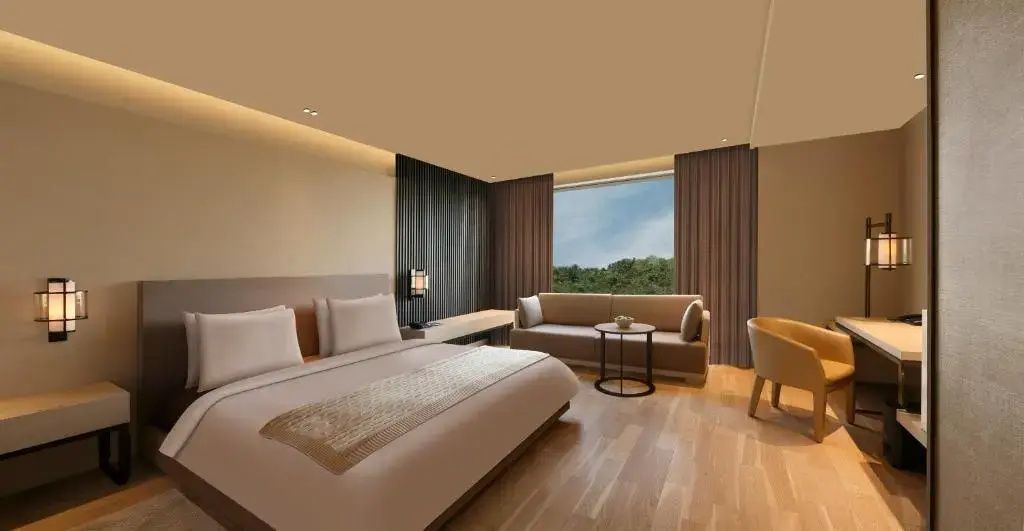 Helles Deluxe Doppelzimmer mit Doppelbett, eleganter Sitzecke und großem Fenster
