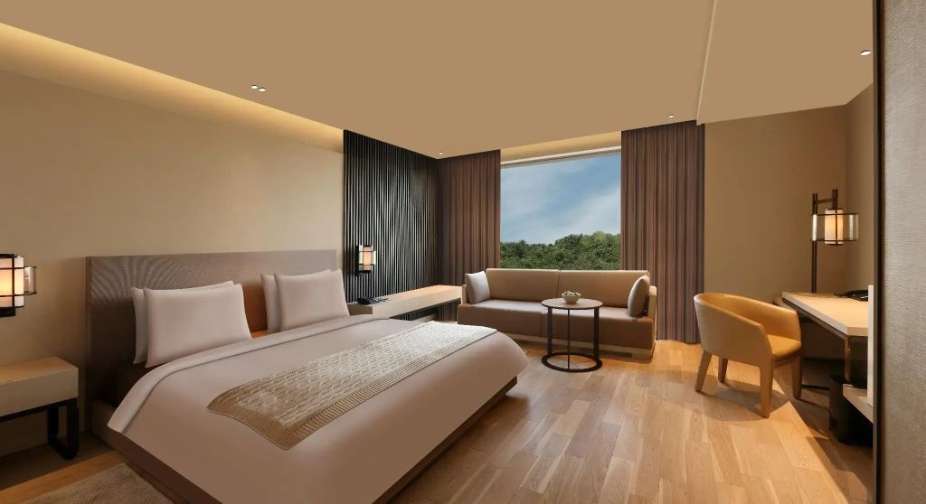 Elegantes Schlafzimmer mit großem Bett in der Executive Suite und Blick ins Grüne