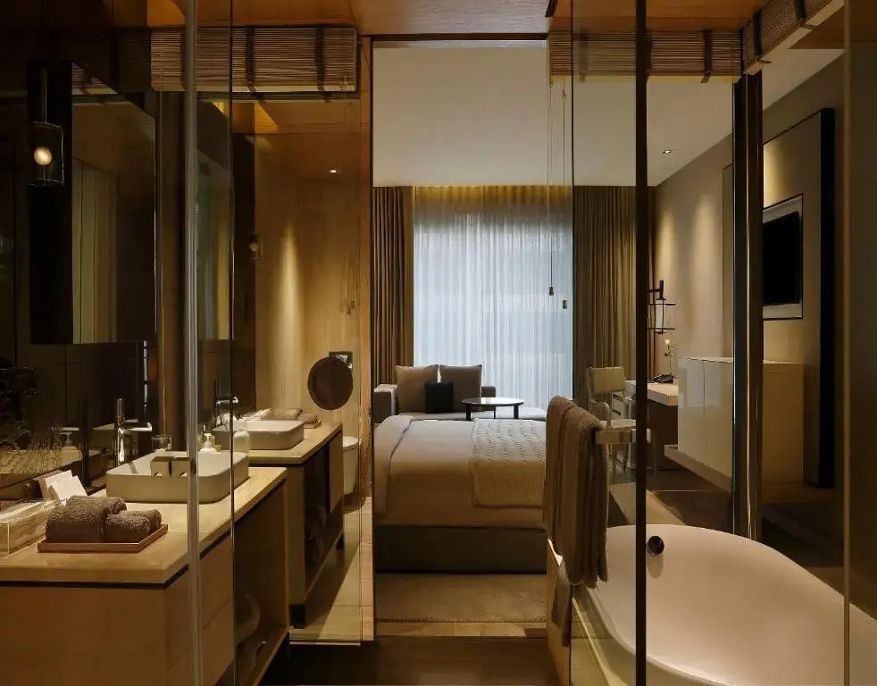 Luxuriöses offenes Badezimmer mit Blick auf das stilvolle Schlafzimmer und großer Fensterfront.