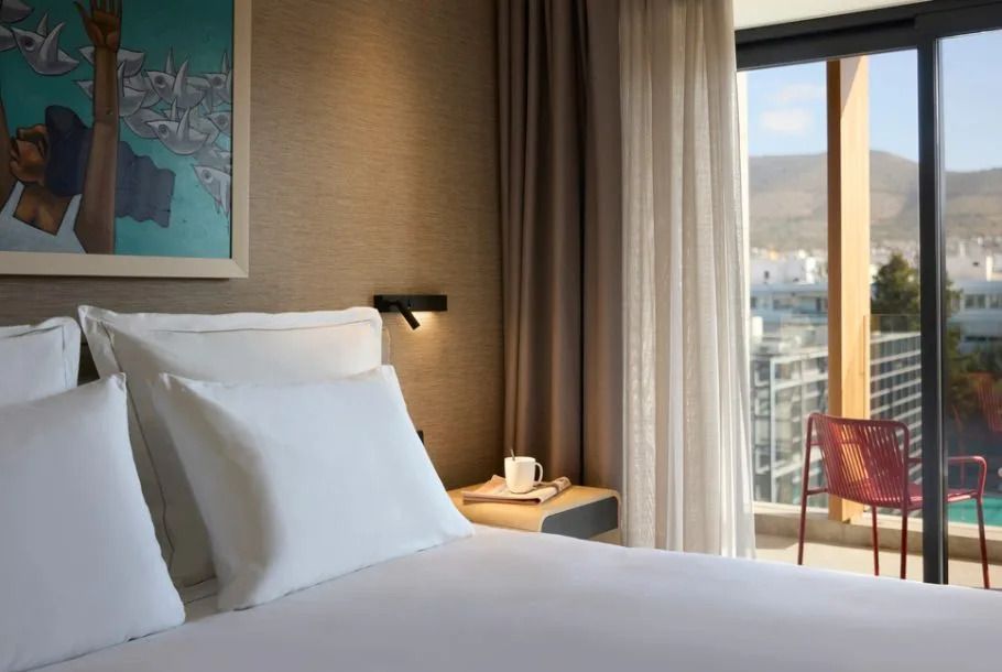 Modernes Schlafzimmer mit Kunst an der Wand und Blick auf die Stadt